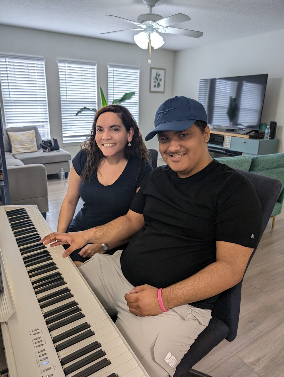 Raiza and Alejandro sharing a piano lesson